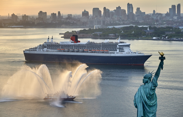 Le Queen Mary 2 devant la statue de la liberté, saluée par les pompiers de New York